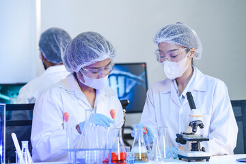 Diverse team of scientists in protective gear collaborating in modern blue lab, analyzing DNA helix...