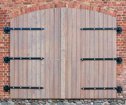 Neues pastellfarbenes zweifl&uuml;geliges Tor aus Holz mit schwarzen Scharnieren in einer roten Backsteinfassade - Bretter mit hellen Fusseln auf der Oberfl&auml;che