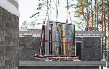 A crane lifts plastic windows at a construction site