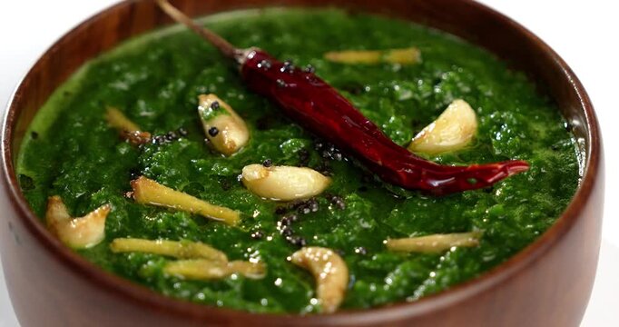 Makki Ki Roti & Sarson Ka Sag is basically Corn floor flat bread & curry using mustard greens respectively. Popular Punjabi food. Served in a bowl and plate over moody background. selective focus