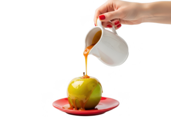 Pouring caramel sauce over a green apple on a red plate, isolated on transparent background