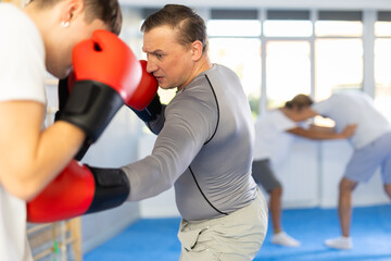 Two athlete men in sportswear practicing boxing sparring in the hall