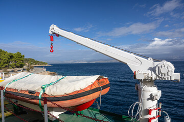 A small crane on a ship used to lower a lifeboat.