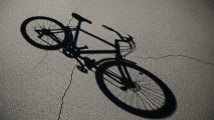 Shadow of a bicycle cast on pavement, artistic overhead capture, minimal aesthetic.