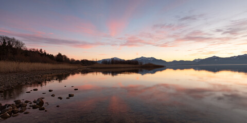Ruhiger Morgen am Chiemsee mit rötlichem Sonnenaufgang