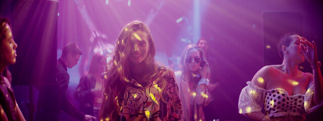 Party atmosphere filled with colorful lights and lively people enjoying music and dancing in a club setting during the night