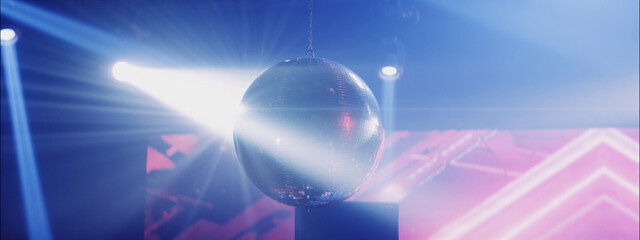 Disco ball reflecting colorful lights during an energetic dance party at a lively venue