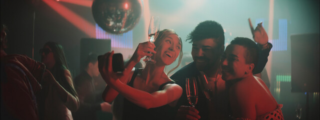 Friends enjoy a lively night out at a vibrant party with drinks and dancing in a colorful club atmosphere