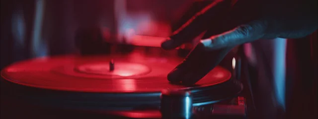 Vibrant DJ spinning vinyl records in a colorful nightclub setting at night © Videophilia