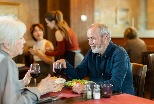 Mature couple communicate and chatting during date in cafe, have rendezvous, lovers tryst. Participants of meeting get to know each other, joke and communicate during meeting
