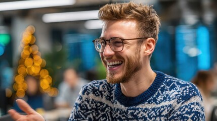 Happy young man in festive sweater laughing in an office with bokeh lights