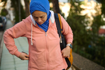Muslim Woman In Hijab With Pink Hoodie And Backpack On Urban Street