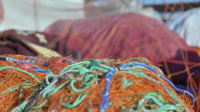 Fishing Nets Are Waiting In A Pile Among Fishing Boats In The Port