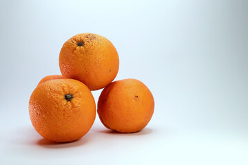Close Up Studio Shot Of Orange Citrus Fruits Piled Together. The Pitted Skin Texture Indicates Natural Ripeness And Freshness Of The Oranges.
