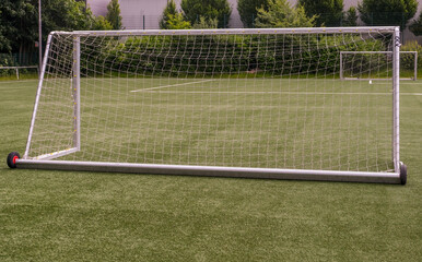 Fototapeta premium Blick auf einen Fußballplatz mit Kunstrasen während einer Trainingseinheit mit vielen aufgebauten Toren auf der Spielfläche