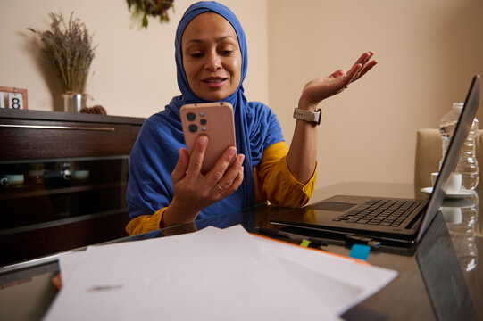 Muslim Woman Working From Home in Europe With Hijab, Laptop, and Smartphone