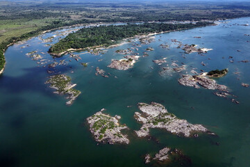 Aerial view of a vast river with numerous rocky islands and lush green vegetation along the banks