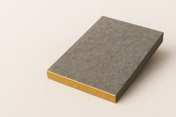 Flat gift box with a gold end on a light surface. Space for text.