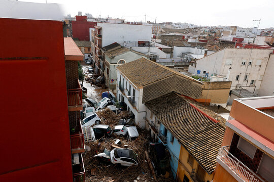 View from above of a narrow street in a european city filled with debris and abandoned vehicles after a natural disaster - Powered by Adobe