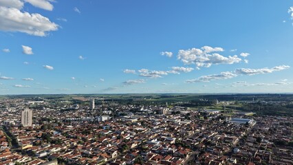 Aerial view of a city with buildings under a blue sky with scattered clouds