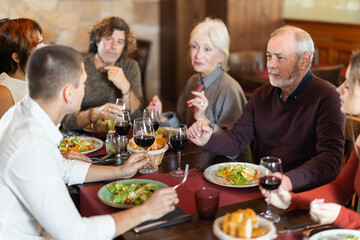 Family members having lively talk while dining in restful restaurant environment
