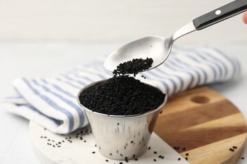 Taking aromatic black caraway at table, closeup