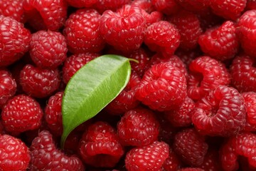 Fresh ripe raspberries and leaf as background, top view