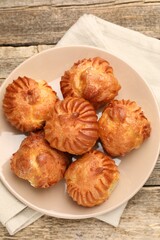 Tasty profiteroles on wooden table, top view