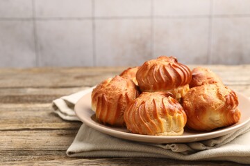 Tasty profiteroles on wooden table, closeup. Space for text