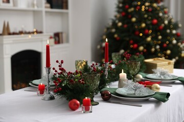 Festive table setting with Christmas decor and burning candles indoors, closeup