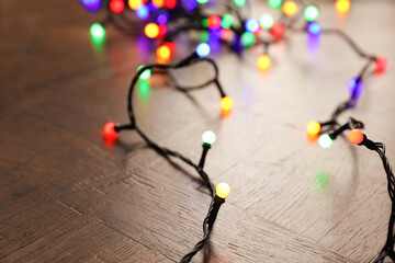 Bright Christmas lights on wooden table, closeup