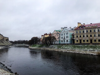 Winter scene along the Pskova River embankment in the city of Pskov, Russia. The Golden Embankment covered in snow creates a calm atmosphere, concept of seasonal tourism and cold weather charm.