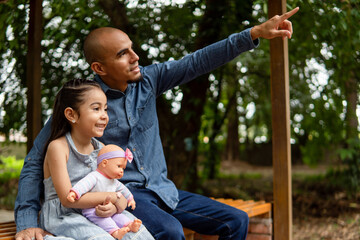 Father and daughter exploring nature together pointing