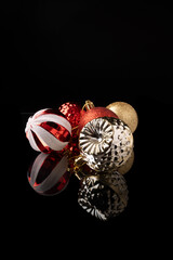 Christmas ornaments, beautiful Christmas ornaments positioned on a mirrored surface, black background, selective focus.