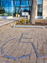 Accessible parking symbol and sign in front of modern glass building on a sunny day