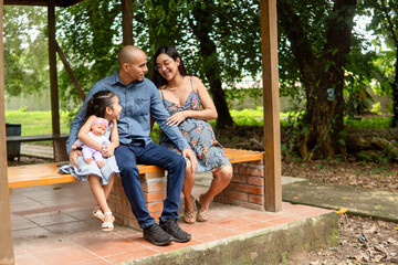 Fototapeta premium Pregnant mother and family enjoying park outing together