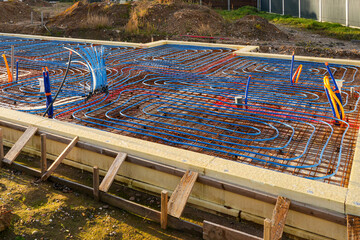 Underfloor heating installation with pipes and rebar grid prepared for concrete foundation