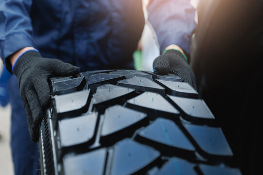 Maintenance service, replacing tires on wheels of industry truck in garage