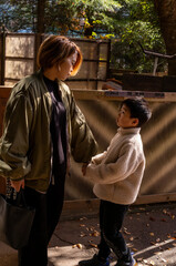 Fototapeta premium Mother and son holding hands and talking in warm afternoon light