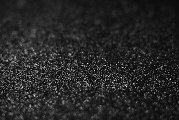 Black glitter bokeh background with sparkling defocused light