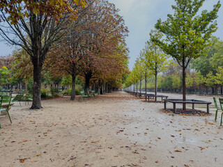 Beautiful view of Tuileries Garden in Paris France, showcasing vibrant autumn colors, iconic pathways, and the stunning backdrop of historic city landmarks