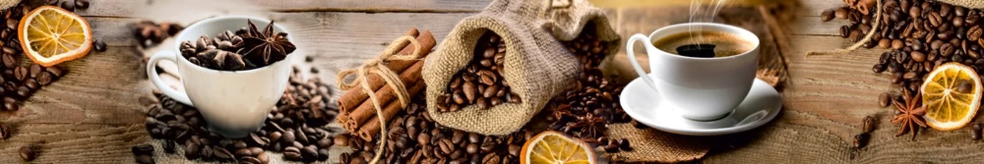 Selbstklebende Fototapeten Cafe Rustic coffee composition with cup of espresso, coffee beans, cinnamon sticks, and dried orange slices on wooden background  © MonTeArt