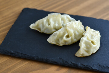 Gyozas on slate board on wooden table