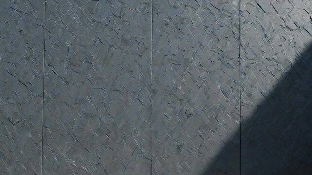 Textured gray wall panels with light shadows, geometric surface detail, separated by vertical seams