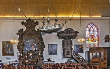 Interior of the Capuchin Church in Ostend, Belgium. A suspended ship model, called an ex-voto, is a notable feature of many coastal churches.