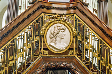 Obraz premium detail of an ornate structure, likely a pulpit loft staircase, featuring a marble or stone relief medallion of a classical profile inside St Salvador Cathedral, Bruges, Belgium 