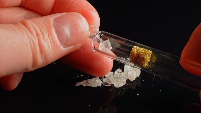Placing crystals of drug in glass smoking pipe concept. Preparation for safe smoking or consumption of Fentanyl, Cocaine, Crystal meth or Crack Cocaine.