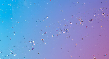 Refreshing abstract background with numerous small water droplets scattered across a vibrant blue and purple gradient, creating a dynamic texture