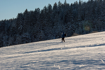 Walking through deep snow in the german mountains in Black Forest