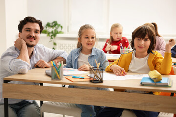 Teacher explaining information to children during lesson in classroom
